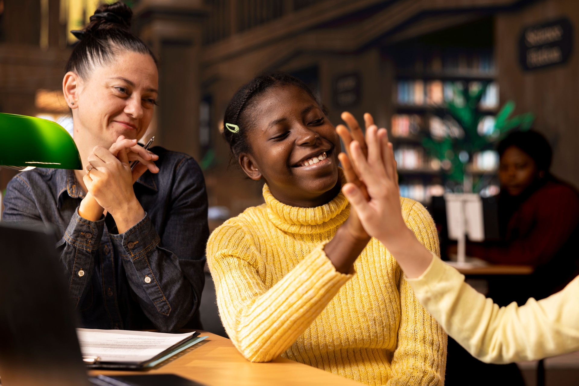 Diverse teen scholars doing high five gesture at the end of tutoring session